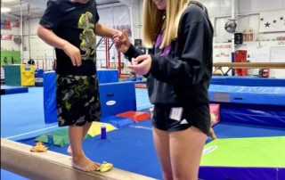 Preschool boy in gymnastic class with a caring coach