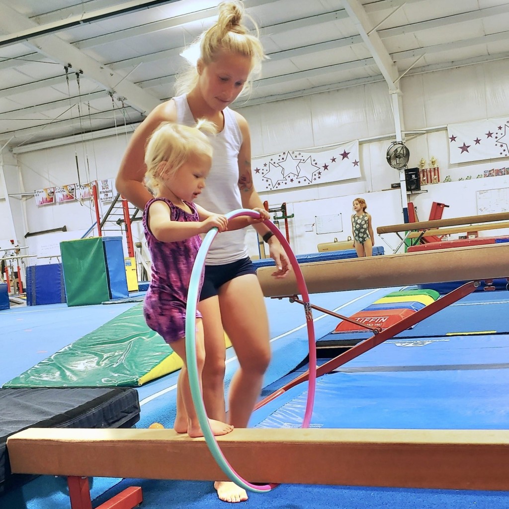 Mom and daughter in toddler gymnastics on balance beam
