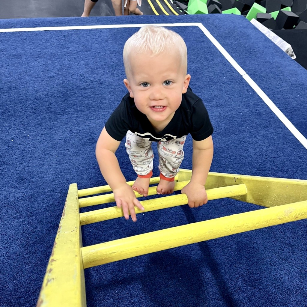 Toddler boy on ladder in toddler gymnastics class