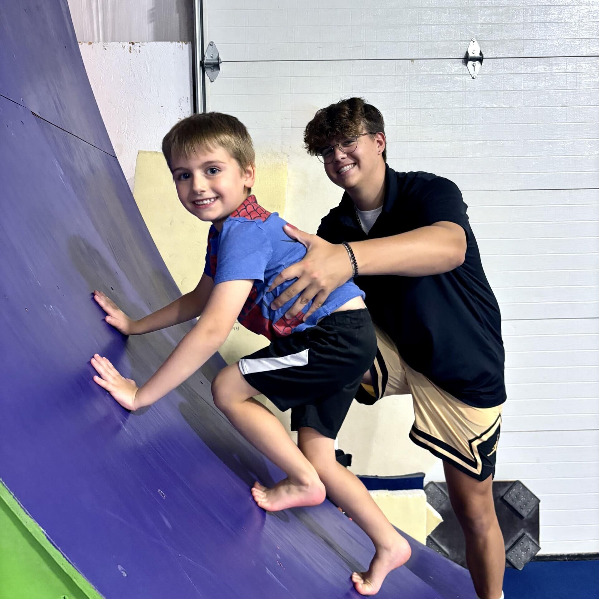 Coach with boy on warped wall at Emeth Summer Camp Coach helping boy climb ninja warped wall at Emeth Summer Day Camp