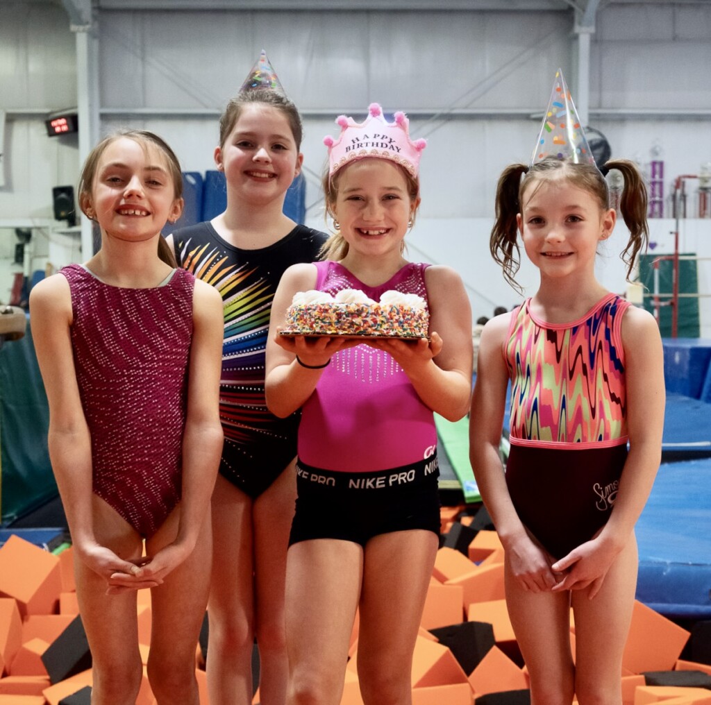 Girls birthday party at EmethGym Girl next to cake at Emeth birthday party