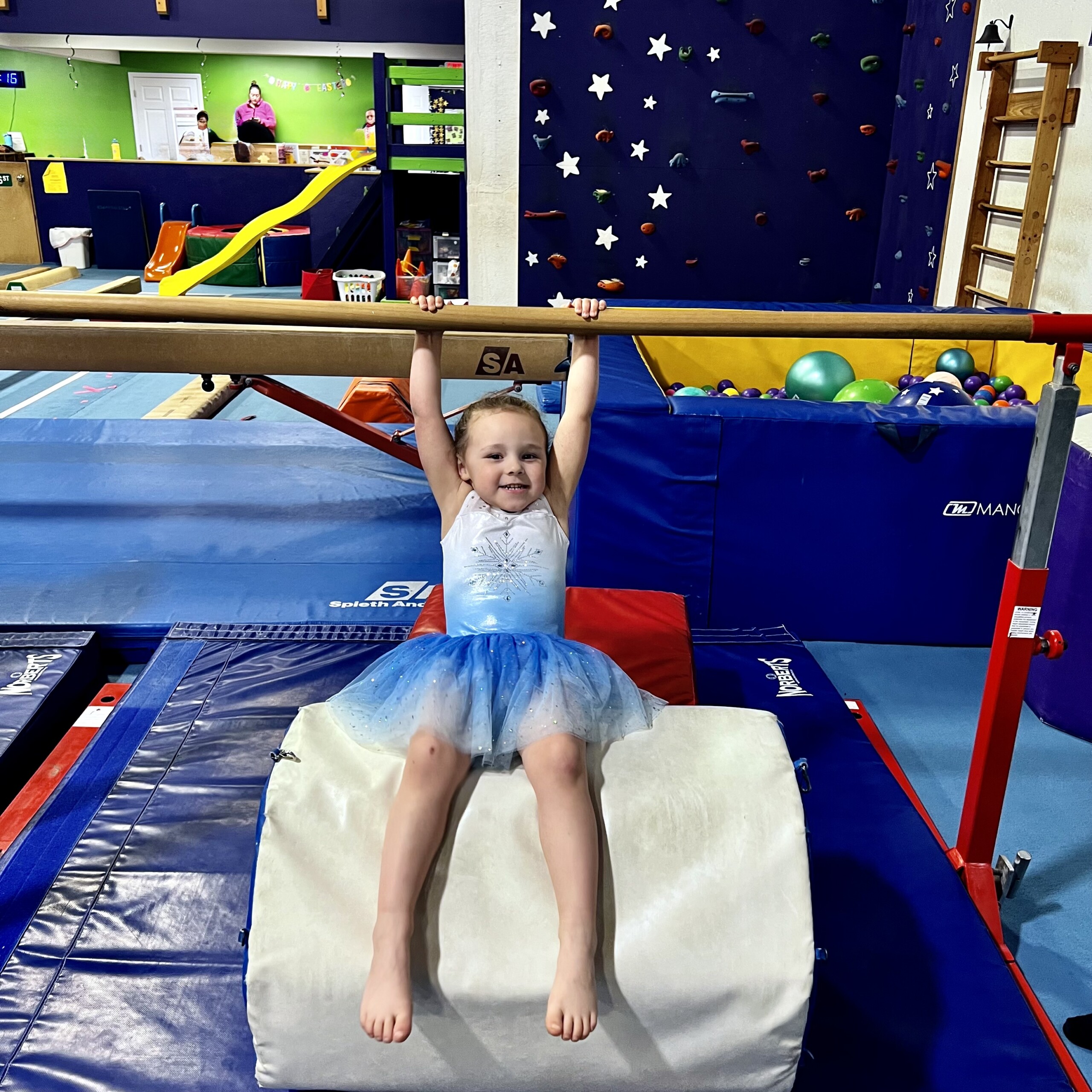 Preschool girl on bars in a gymnastics class Mom and daughter in toddler gymnastics on balance beam