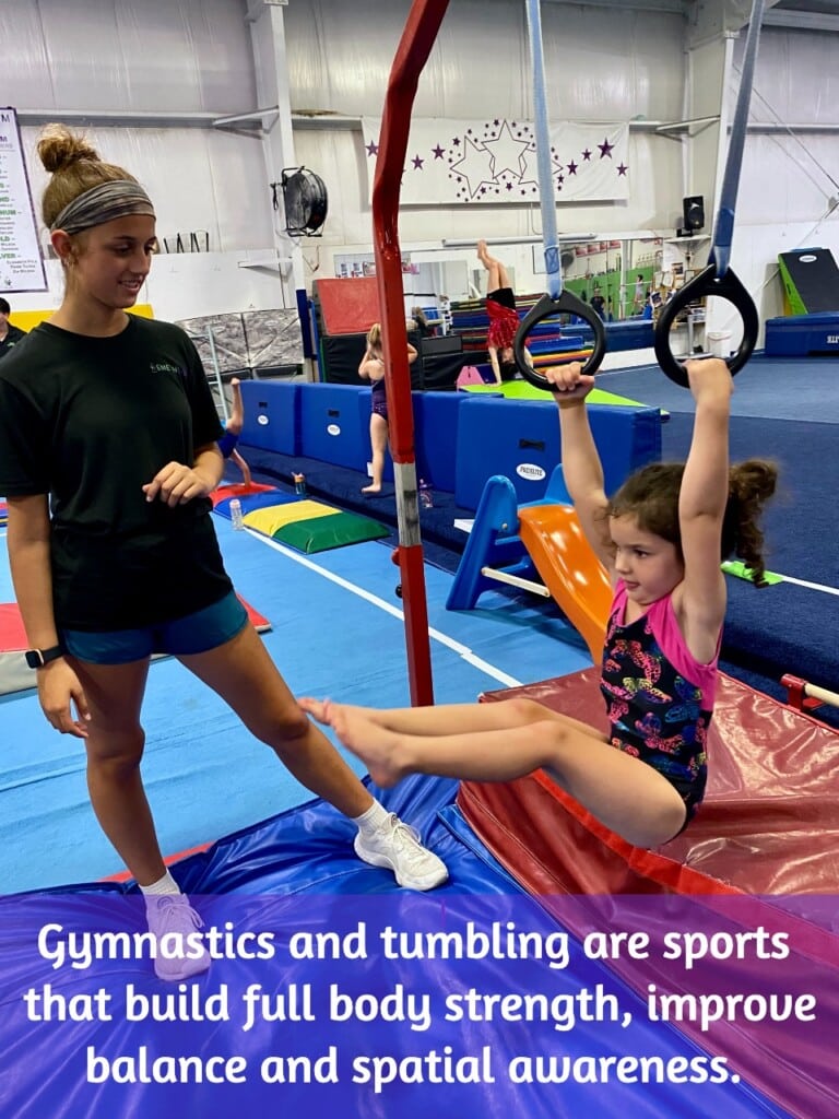 Student in gymnastics class hanging on rings